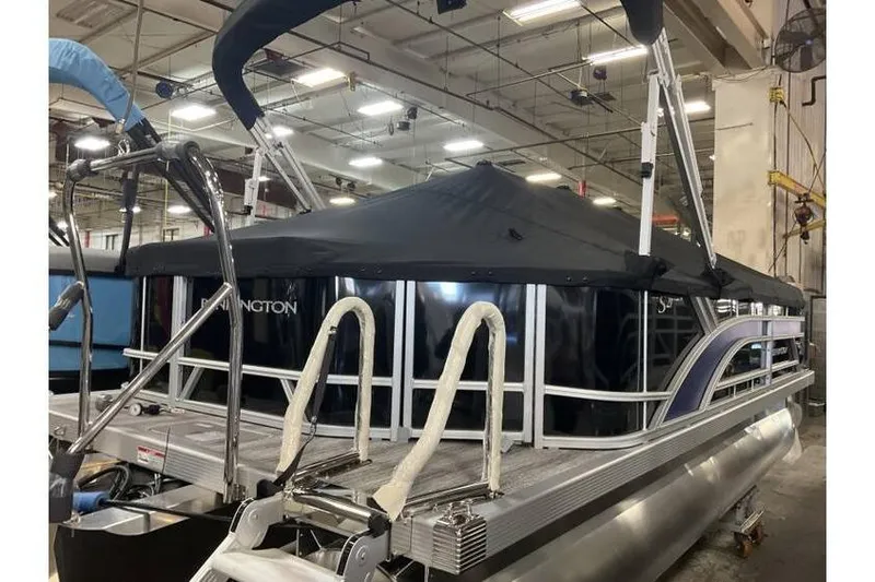 Slide: The Image of 2026 Bennington 21 SL pontoon boat with privacy curtain, in stock at indoor facility. - 11