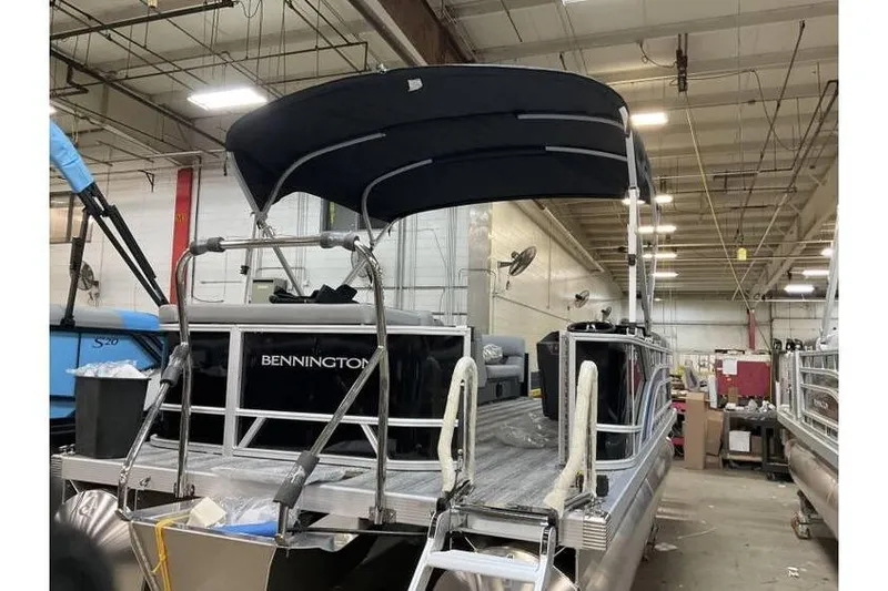 Slide: The Image of 2026 Bennington 21 SL pontoon boat with privacy curtain in warehouse setting. - 7