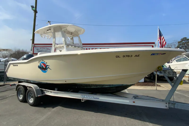 Slide: The Image of 2014 Tidewater 250 CC Adventure boat on trailer, displayed at a dealership. - 1