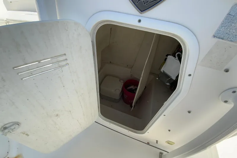 Slide: The Image of 2014 Tidewater 250 CC Adventure boat storage compartment with open door, showing interior items. - 25