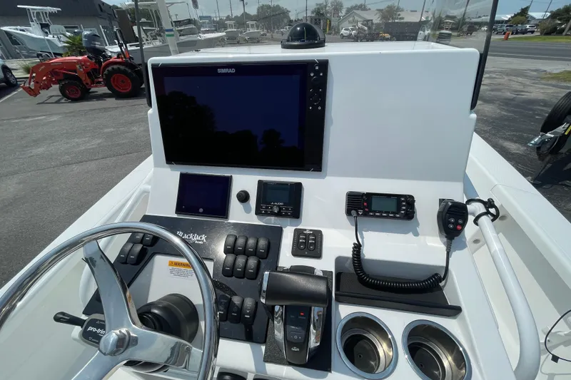 Slide: The Image of Control panel of 2023 BlackJack 256 Bay boat with steering wheel and electronic displays. - 11