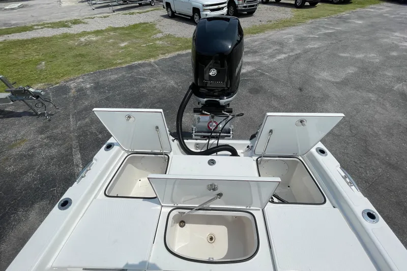 Slide: The Image of 2023 BlackJack 256 Bay boat with open storage compartments and outboard motor. - 18