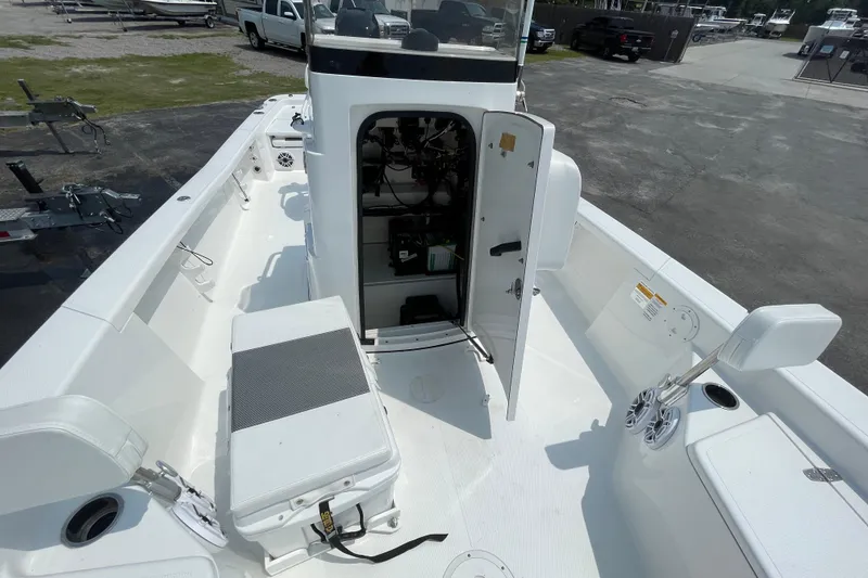 Slide: The Image of 2023 BlackJack 256 Bay boat interior with open storage compartment and seating. - 21