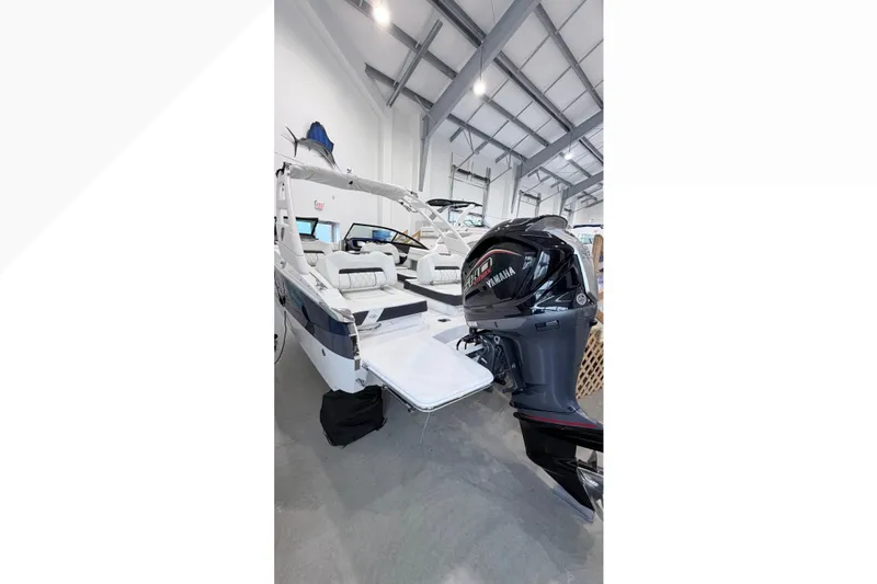 Slide: The Image of 2025 Regal LX2 boat with Yamaha outboard motor in showroom setting. - 10