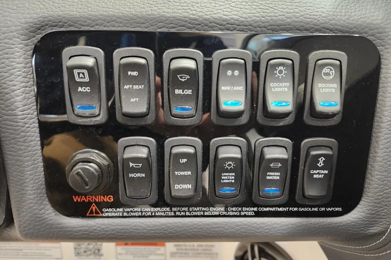 Slide: The Image of Control panel of 2025 Regal LX2 boat with various switches and warning label. - 17