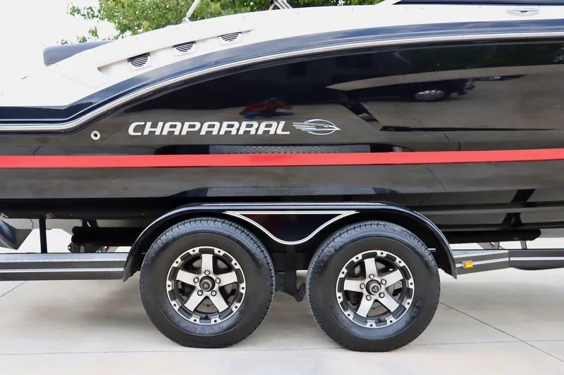 Slide: The Image of 2017 Chaparral 227 SSX boat on trailer, featuring sleek black design with red stripe. - 11