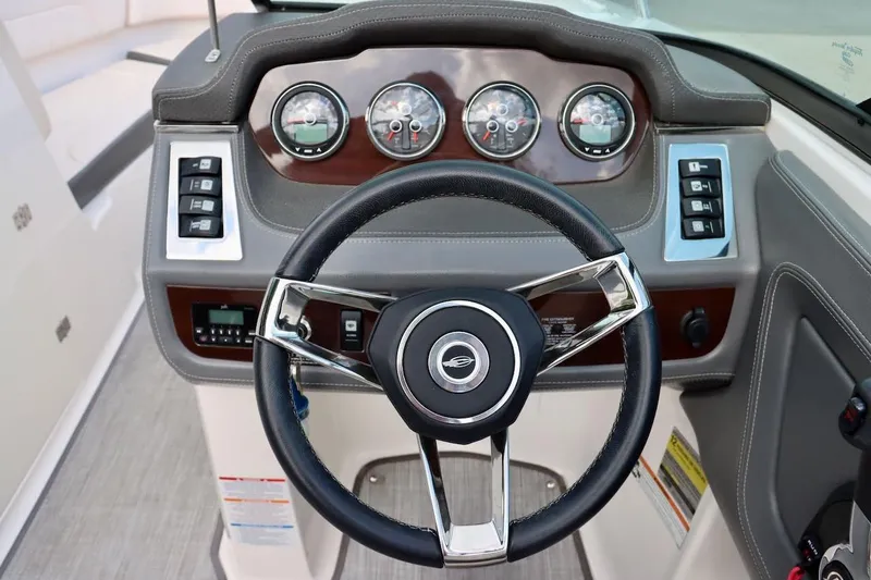 Slide: The Image of Steering wheel and dashboard of 2017 Chaparral 227 SSX boat, featuring gauges and controls. - 19