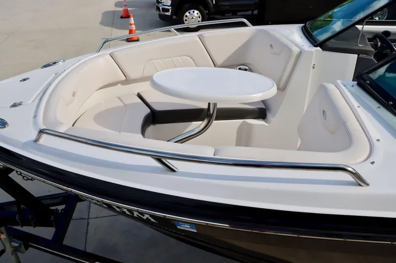 Slide: The Image of 2017 Chaparral 227 SSX boat interior with seating and table, parked on a trailer. - 26