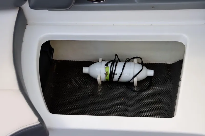 Slide: The Image of Storage compartment in 2017 Chaparral 227 SSX boat with a secured white cylinder. - 39