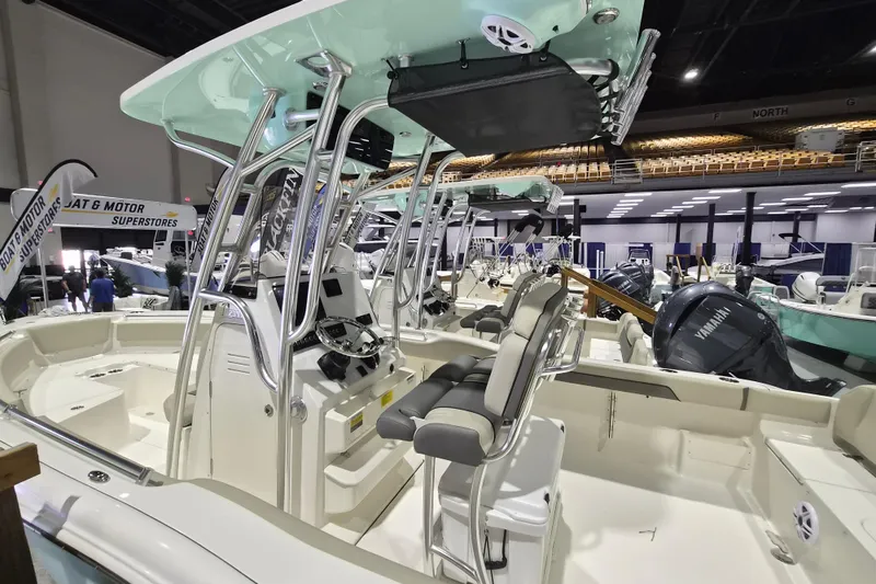 Slide: The Image of 2026 Key West 239 FS boat interior at a showroom, featuring modern seating and controls. - 2