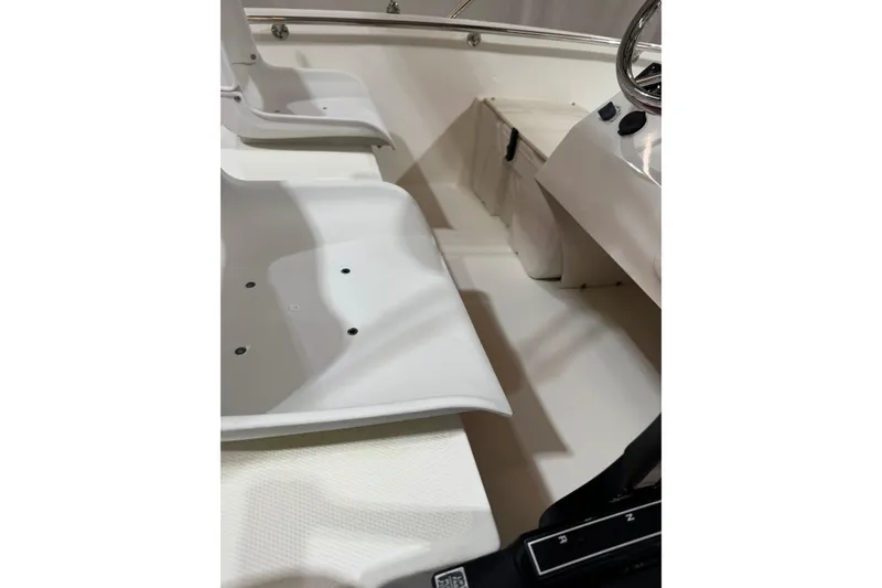 Slide: The Image of 2015 Boston Whaler 150 Super Sport interior with white seating and steering console. - 2