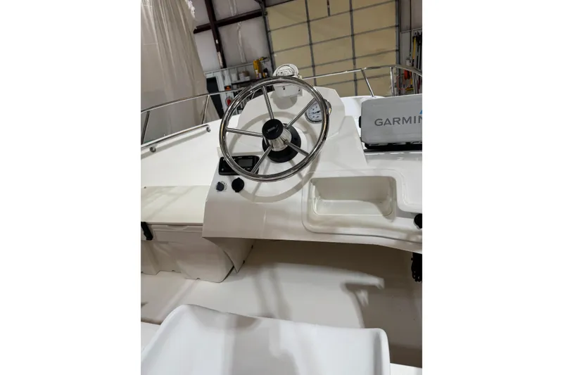 Slide: The Image of 2015 Boston Whaler 150 Super Sport boat dashboard with steering wheel and Garmin device. - 4