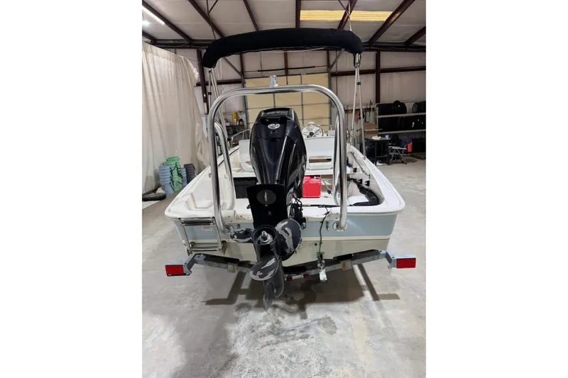 Slide: The Image of 2015 Boston Whaler 150 Super Sport boat in a garage, rear view. - 6