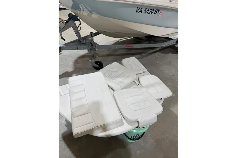 Slide: The Image of 2015 Boston Whaler 150 Super Sport boat with white seats and trailer in garage. - 8