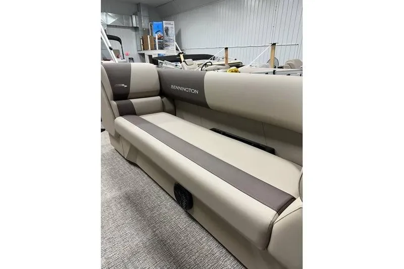 Slide: The Image of 2026 Bennington 21 SSR Quad Bench interior, featuring beige and brown seating in showroom. - 15