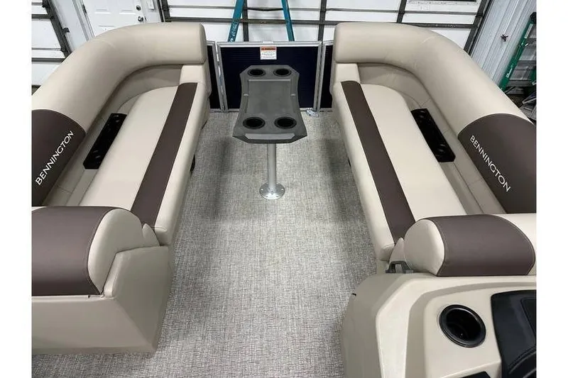 Slide: The Image of 2026 Bennington 21 SSR Quad Bench interior with beige seating and central table. - 17