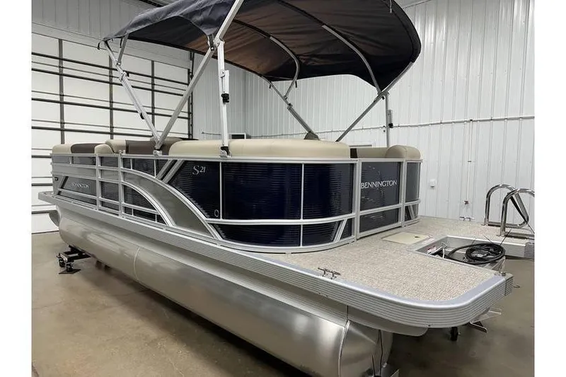 Slide: The Image of 2026 Bennington 21 SSR Quad Bench pontoon boat in stock, displayed indoors. - 6