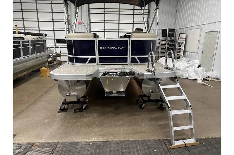 Slide: The Image of 2026 Bennington 21 SSR Quad Bench pontoon boat in stock, displayed indoors. - 8