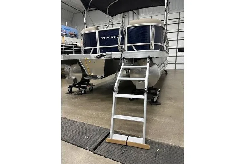 Slide: The Image of 2026 Bennington 21 SSR Quad Bench pontoon boat with ladder in showroom. - 9