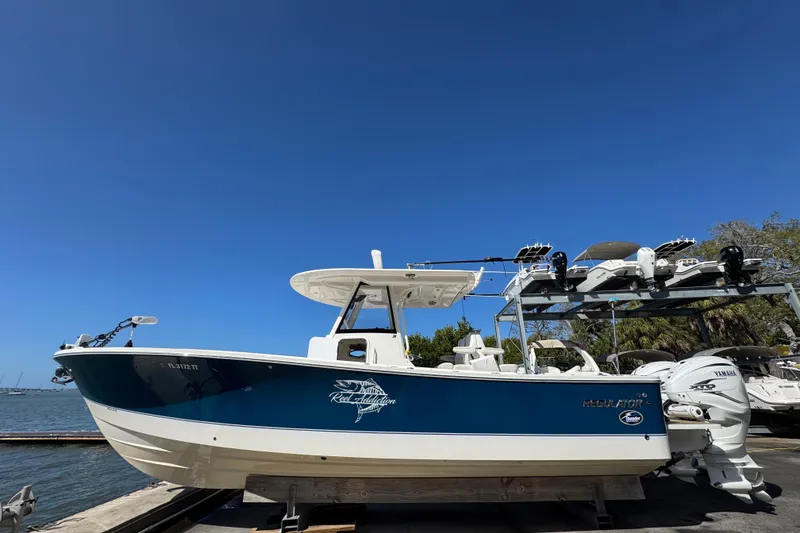 The Image of 2023 Regulator 31 boat docked by the water under a clear blue sky. - 0