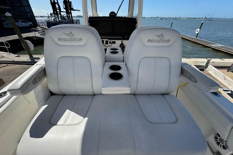 Slide: The Image of 2023 Regulator 31 boat seats with cup holders, docked by the water. - 11