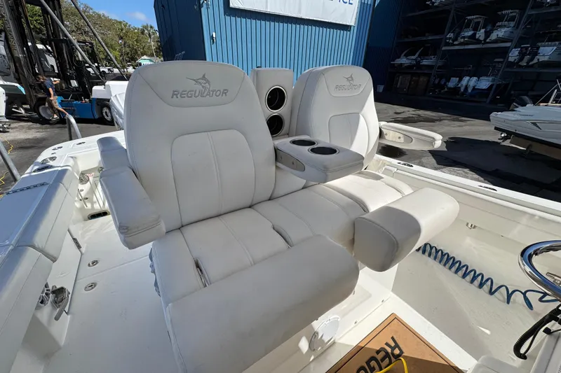 Slide: The Image of 2023 Regulator 31 boat with white cushioned seating and cup holders. - 13