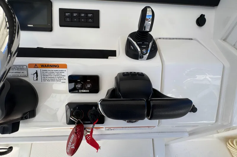 Slide: The Image of 2023 Regulator 31 boat control panel with Yamaha controls and warning label. - 15