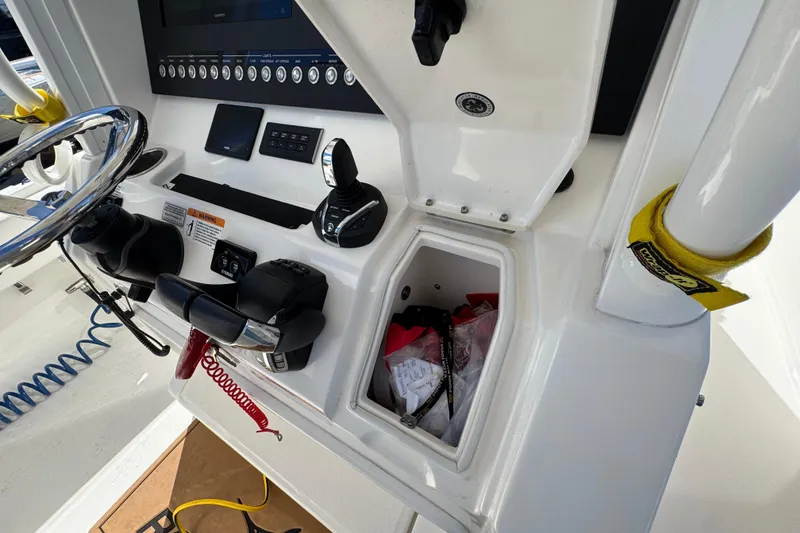 Slide: The Image of 2023 Regulator 31 boat console with steering wheel, controls, and storage compartment. - 16