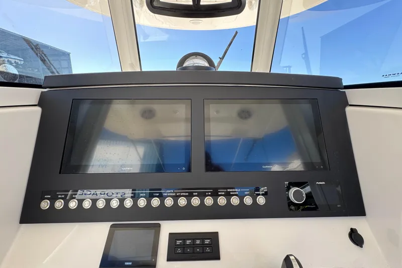 Slide: The Image of 2023 Regulator 31 boat dashboard with dual Garmin displays and control panel. - 17