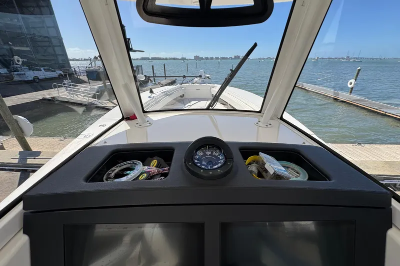Slide: The Image of 2023 Regulator 31 boat dashboard with compass, docked at marina. - 18