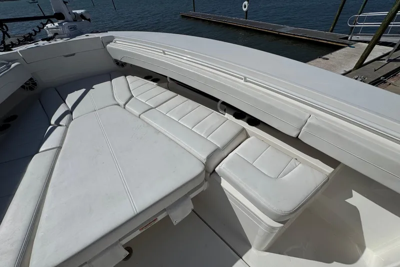 Slide: The Image of 2023 Regulator 31 boat interior with white cushioned seating, docked by the water. - 26