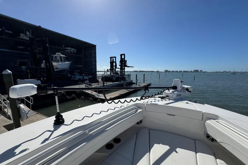 Slide: The Image of 2023 Regulator 31 boat docked at marina with clear blue sky and water view. - 27