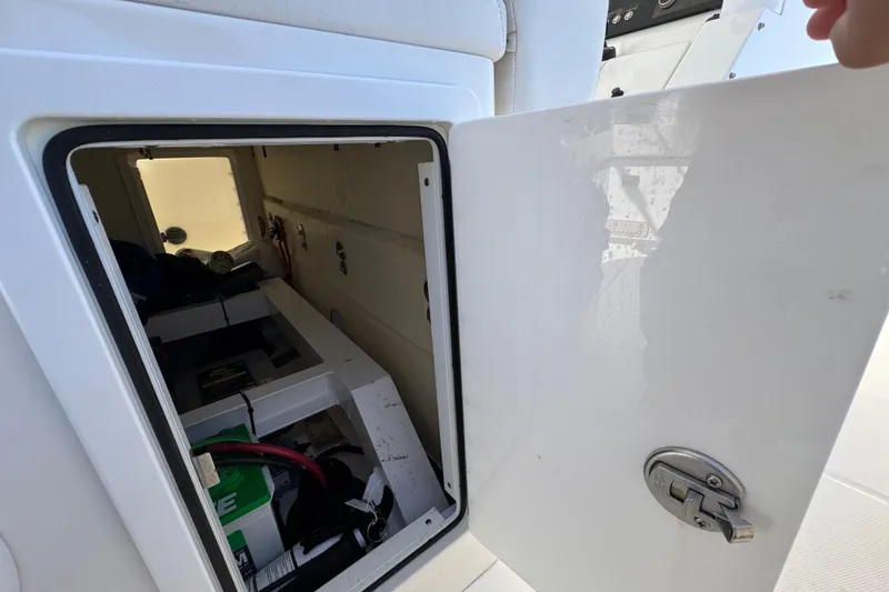 Slide: The Image of Open storage compartment on a 2023 Regulator 31 boat, showing interior equipment and wiring. - 29