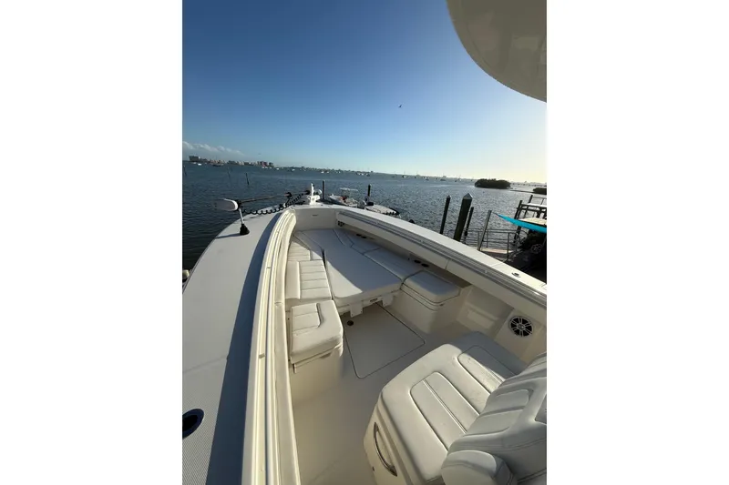 Slide: The Image of 2023 Regulator 31 boat with spacious seating, docked by a scenic waterfront. - 34