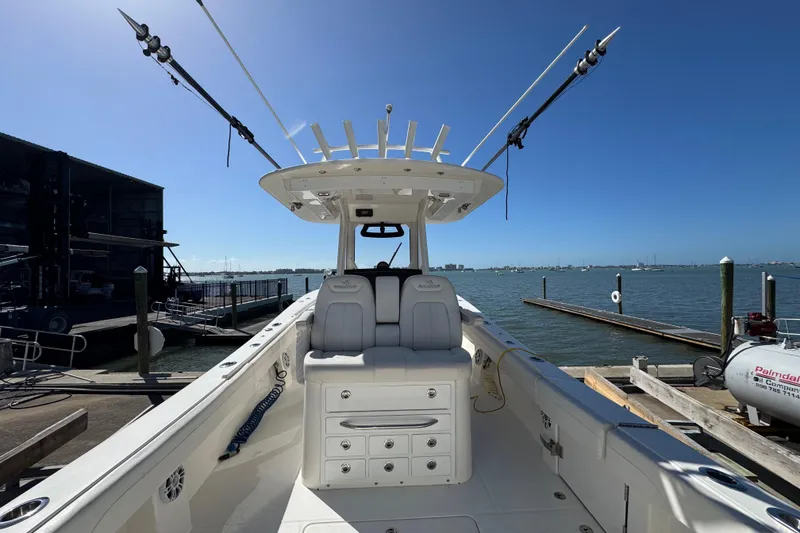 Slide: The Image of 2023 Regulator 31 boat docked, featuring spacious seating and fishing rod holders. - 4