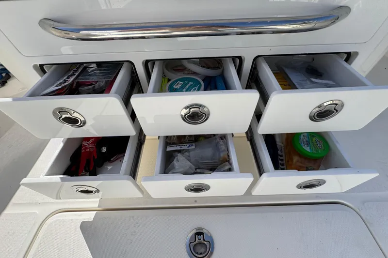 Slide: The Image of Open storage drawers on a 2023 Regulator 31 boat, containing various items. - 9