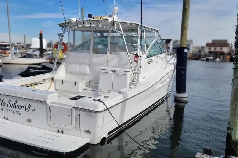 Slide: The Image of 2011 Rampage 41 Express boat docked in marina, rear view, clear sky. - 2