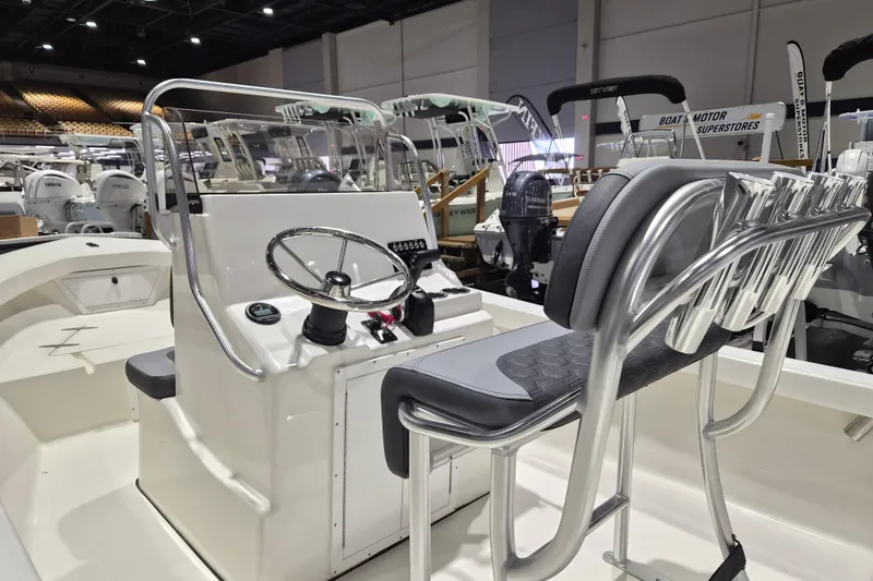Slide: The Image of 2026 May-Craft 192 CC boat interior with steering console and seating at a boat show. - 4
