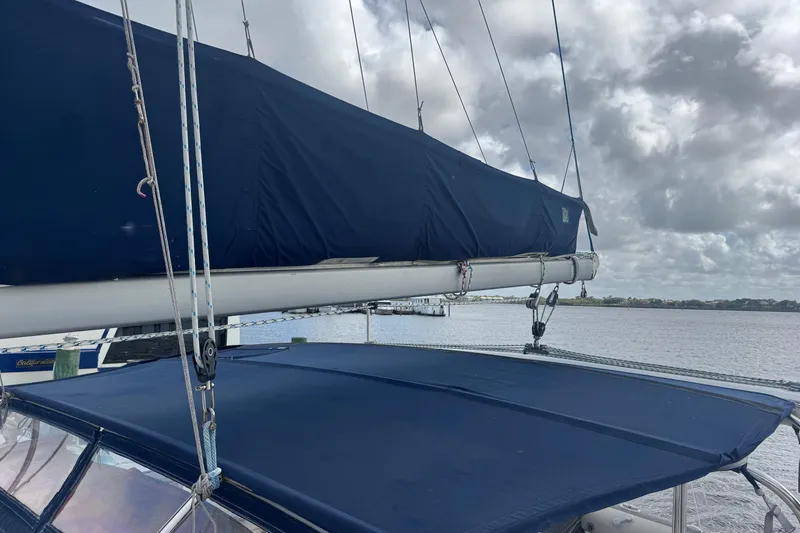Slide: The Image of Sailboat Leopard 42, 2002 model, with blue canvas cover on a cloudy day. - 22