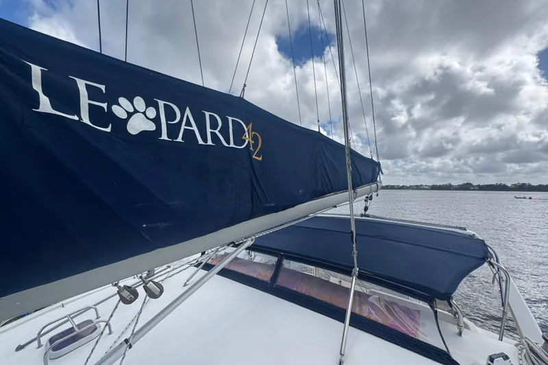 Slide: The Image of Sailboat with "Leopard 42" branding, 2002 model, on a cloudy day at sea. - 24
