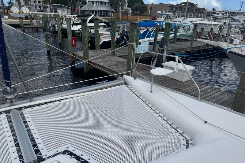 Slide: The Image of Catamaran Leopard 42 docked at marina, showcasing deck and netting, 2002 model. - 26