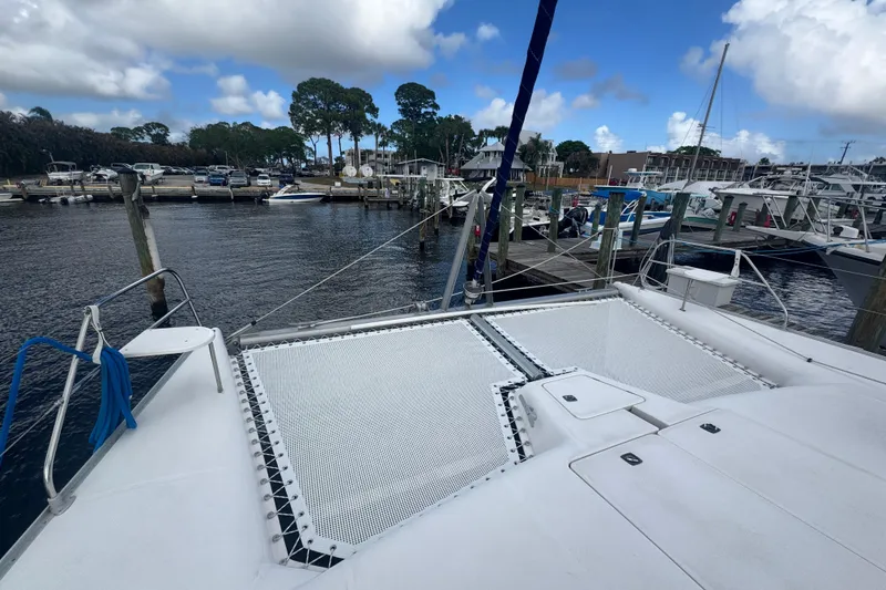 Slide: The Image of Catamaran Leopard 42, 2002 model, docked at marina with clear sky and boats. - 27