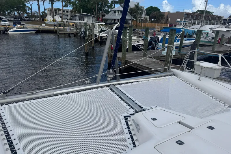 Slide: The Image of Catamaran Leopard 42 (2002) docked at marina with visible netting and water view. - 28