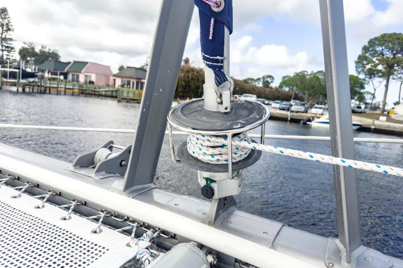 Slide: The Image of Sailing equipment on a 2002 Leopard 42 catamaran, docked near waterfront homes. - 29