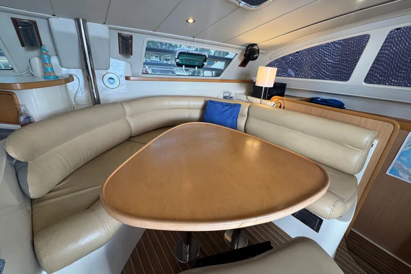 Slide: The Image of Luxurious interior of a 2002 Leopard 42 yacht with beige seating and wooden table. - 30