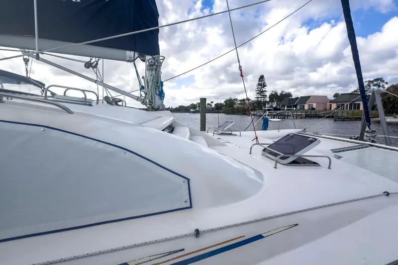 Slide: The Image of 2002 Leopard 42 catamaran docked by a scenic waterfront with cloudy skies. - 4