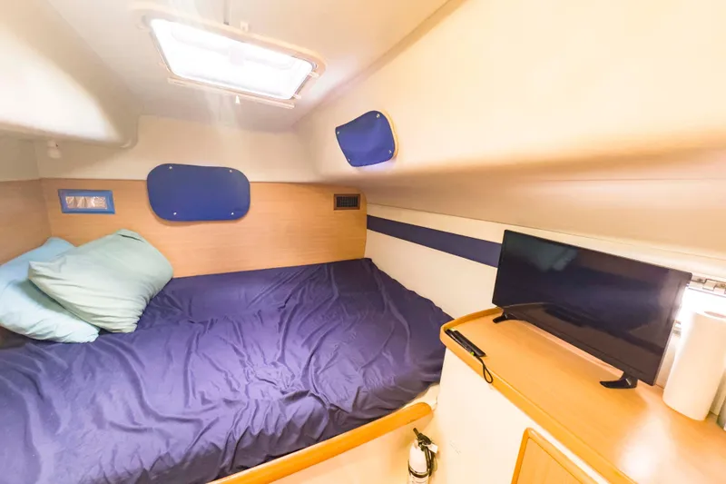 Slide: The Image of Cozy cabin interior of 2002 Leopard 42 yacht with bed and TV setup. - 46