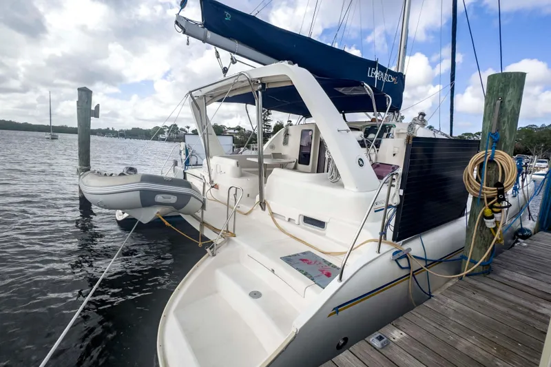 Slide: The Image of Leopard 42 catamaran from 2002 docked with inflatable dinghy, under cloudy sky. - 5