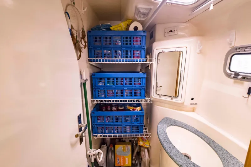 Slide: The Image of Storage area in a 2002 Leopard 42 yacht with blue crates and a small sink. - 59