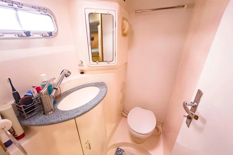 Slide: The Image of Compact bathroom in a 2002 Leopard 42 yacht with sink, mirror, and toilet. - 69